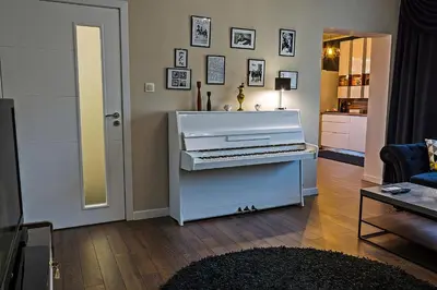 a white piano sitting in a living room at Guest House Amaya in Plovdiv