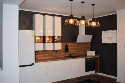 a kitchen with white cabinets and a sink and lights at Guest House Amaya in Plovdiv