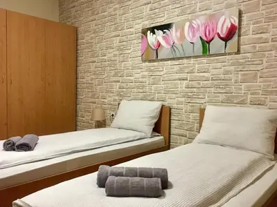 two beds in a room with flowers on the wall at Snow Apartment - Bansko in Bansko