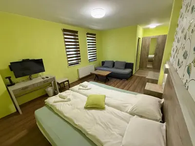 a bedroom with a large white bed and a couch at Berghof Eva - Hotel in Panichishte