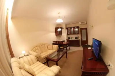 a living room with two couches and a tv at Downtown Bansko Resort in Bansko