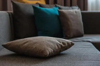 a brown pillow sitting on a couch with pillows at THE STAY Boutique Hotel Central Square - Free Compliments - Free Wi-Fi - TOP LOCATION - Nearby Paid Parking in Plovdiv