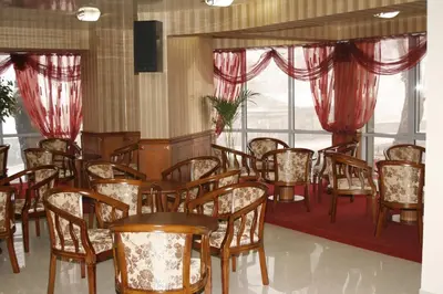 a dining room with chairs and tables and windows at Hotel Elegance in Asenovgrad