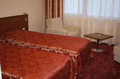 a hotel room with a bed and a chair at Hotel Elegance in Asenovgrad