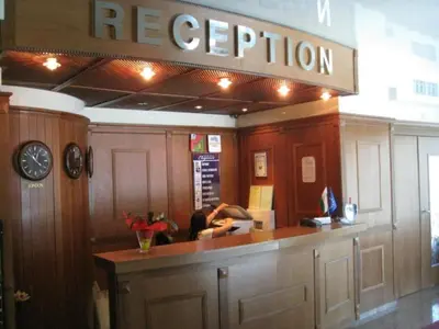 a person sitting at a counter in a restaurant at Hotel Elegance in Asenovgrad