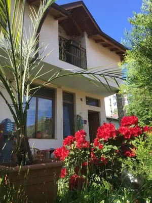 a house with red flowers in front of it at Guesthouse Elizabeth in Samokov