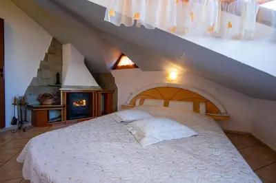 a bedroom with a white bed in a attic at Guesthouse Elizabeth in Samokov