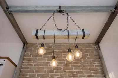 a chandelier with bulbs hanging from a brick wall at The Balkan in Plovdiv