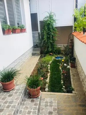 a garden in front of a house with potted plants at Guest house Grahlyov in Sapareva Banya