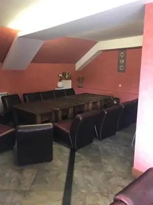 a room with a large table and leather chairs at Hotel Temenuga in Panichishte