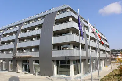 a building with two flags in front of it at Hotel Arena in Samokov