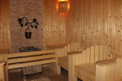 a sauna with chairs and a table and a lamp at Hotel Arena in Samokov