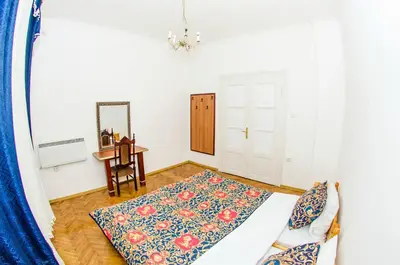 a room with a bed and a table and a mirror at Central GuestHouse Five Corners in Sofia