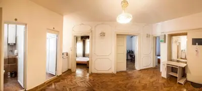 a room with a hallway with wooden floors and a chandelier at Central GuestHouse Five Corners in Sofia