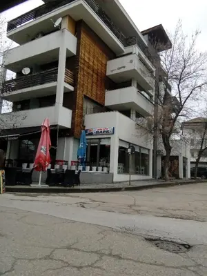 a building with two umbrellas in front of it at Студио Бижу in Hisarya