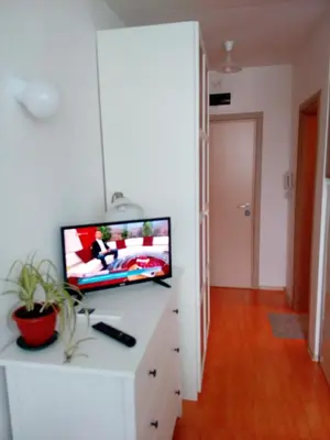 a living room with a tv on a white cabinet at Студио Бижу in Hisarya