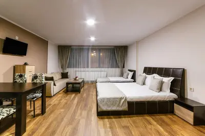 a hotel room with a bed and a couch at Family Hotel Ring & Thermal in Kyustendil