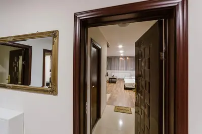 a hallway with a mirror and a living room at Family Hotel Ring & Thermal in Kyustendil