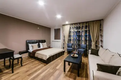 a hotel room with a bed and a couch at Family Hotel Ring & Thermal in Kyustendil