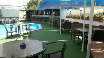a patio with tables and chairs next to a pool at Family Hotel Yagoda88 in Sofia