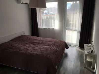 a bedroom with a bed and a large window at ApartVel apartment 1 in Velingrad