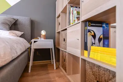 a bedroom with a bed and a table and a book shelf at The Spot - fully equipped, central, modern studio by Flat Mаnager in Sofia