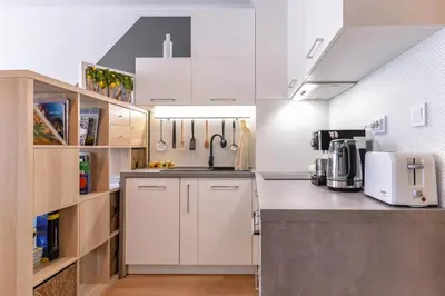 a kitchen with white cabinets and a sink at The Spot - fully equipped, central, modern studio by Flat Mаnager in Sofia