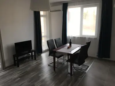 a dining room with a table and chairs and a television at ApartVel apartment 2 in Velingrad