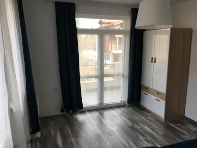 a living room with a large window and a door at ApartVel apartment 2 in Velingrad