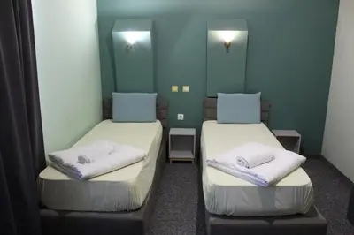 two beds in a room with green walls at Hotel Color in Asenovgrad