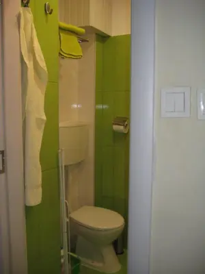 a small bathroom with a toilet and green tiles at Maria Louisa Apartment in Sofia