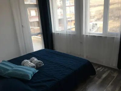 two teddy bears on a bed in a room with windows at ApartVel apartment 3 in Velingrad