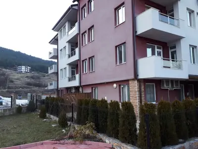 a pink building with a fence in front of it at ApartVel apartment 3 in Velingrad