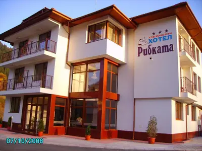 a building with a sign on the side of it at Ribkata Family Hotel in Smolyan