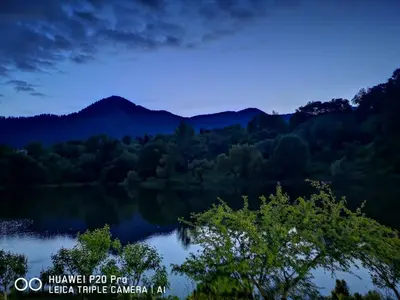 a view of a lake in the mountains at night at Ribkata Family Hotel in Smolyan