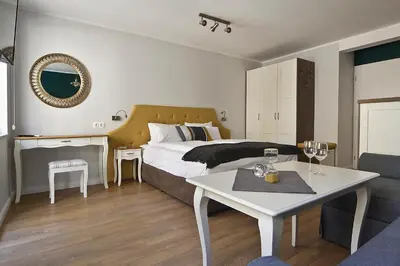 a bedroom with a bed and a table and a couch at Momenti & Colori Studios in Sofia