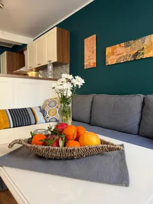 a bowl of fruit on a table with a vase of flowers at Momenti & Colori Studios in Sofia