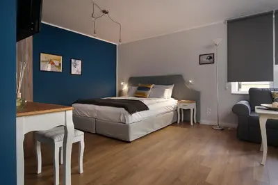 a bedroom with a bed and a blue wall at Momenti & Colori Studios in Sofia