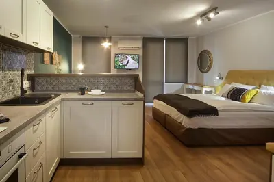 a kitchen and a bedroom with a bed in a room at Momenti & Colori Studios in Sofia