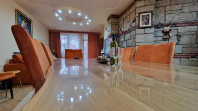 a dining room table with a bottle of wine on it at Apartment 9 in Pamporovo