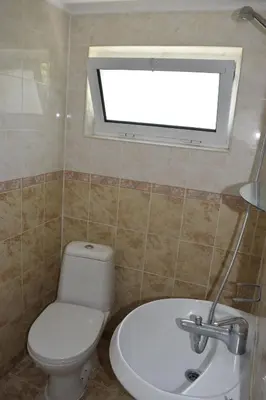 a bathroom with a toilet and a sink and a window at Стаи за гости 