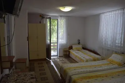 a bedroom with two beds and a window at Стаи за гости 