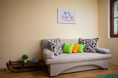 a living room with a couch with colorful pillows at Green Orange Apartment in Bansko