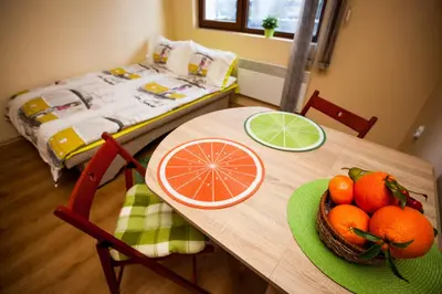 a table with a bowl of oranges and a bed at Green Orange Apartment in Bansko