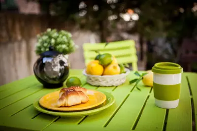 a green table with a plate of food on it at Green Orange Apartment in Bansko