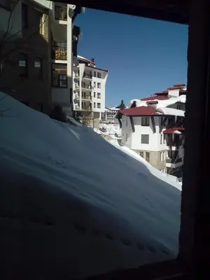 a snow covered hill with buildings in the background at Apartment Аlex in Grand Monastery Pamporovo in Pamporovo