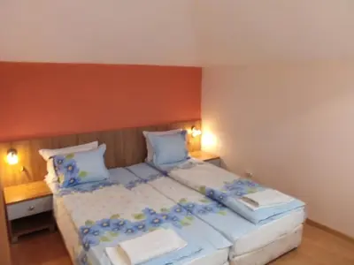 a bedroom with a large bed with blue sheets and pillows at Aleks Guest House in Samokov