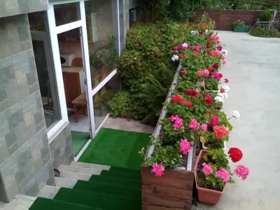 a bunch of flowers in wooden boxes in front of a building at Aleks Guest House in Samokov