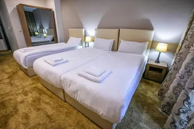 two beds in a hotel room with towels on them at Hotel Andon Angelov in Sandanski