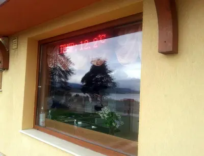 a window with a reflection of a christmas tree in it at Guest house Lidia in Tsigov Chark